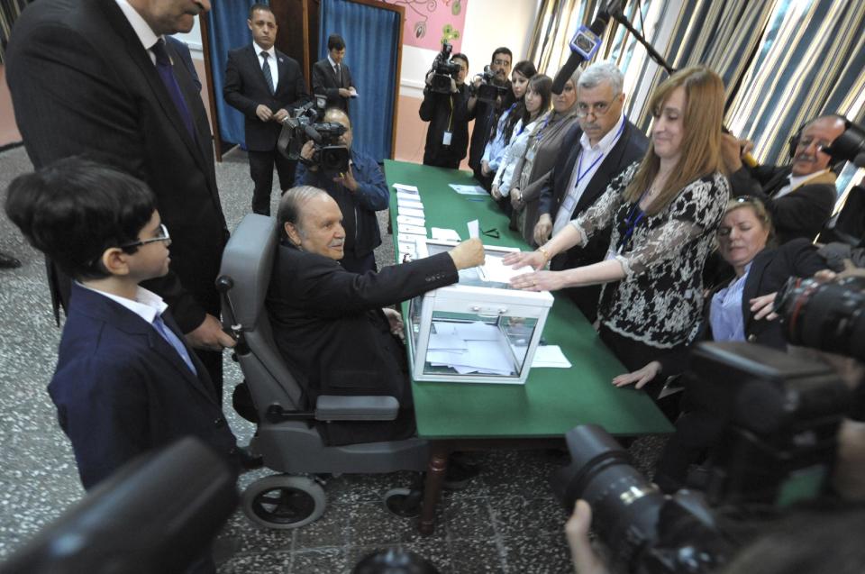 President Abdelaziz Bouteflika, sitting on a wheelchair, is to vote in the presidential elections in Algiers, Thursday, April 17, 2014. Algerians are trickling into the polls to elect a new president of this oil-rich North African nation in an election expected to be won by the ailing incumbent. President Bouteflika has ruled this nation for the past 15 years and, despite suffering from a stroke, is running for a fourth term on a platform of stability. (AP Photo/Sidali Djarboub)