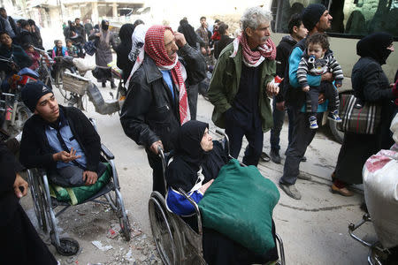 An elderly woman sits in a wheelchair during evacuation from the besieged town of Douma, Eastern Ghouta, in Damascus, Syria March 22, 2018. REUTERS/Bassam Khabieh