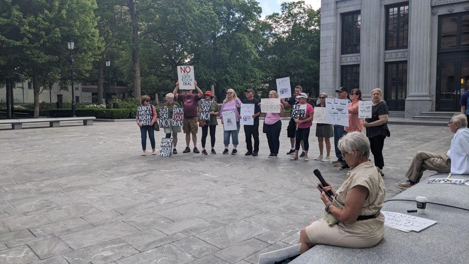 Kathy Thrun, front right, prepares to speak Wednesday to residents protesting a proposed pay raise for Quincy Mayor Thomas Koch in front of City Hall.