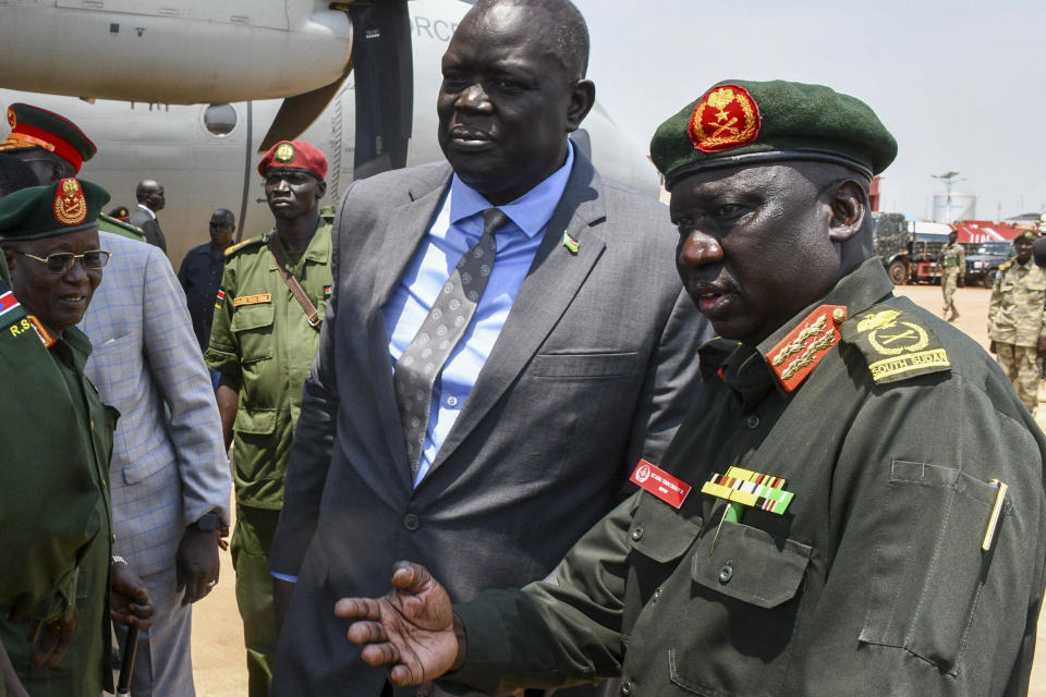 Deputy Chief of Defense Forces Lt. Gen. Thoi Chany Reat, right, accompanied by Acting Minister of Foreign Affairs Deng Dau Deng Malek, center, attends a ceremony for soldiers from the South Sudan People's Defence Forces (SSPDF) preparing to join the East Africa Community Regional Force (EACRF) in Congo, at the airport in Juba, South Sudan Monday, April 3, 2023. A United Nations-backed panel of investigators alleges in a new report that several officials in South Sudan including Reat have perpetrated serious human rights violations and should be held accountable for their crimes. (AP Photo/Samir Bol)