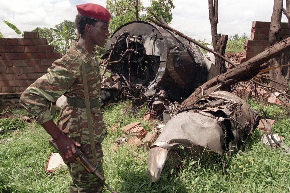 FILE - In this May 23, 1994 file photo, a Rwanda Patriotic Front (RPF) rebel walks by the the site of an April 6 plane crash which killed Rwanda's President Juvenal Habyarimana in Kigali, Rwanda. A report commissioned by the Rwandan government due to be made public on Monday, April 19, 2021 concludes that the French government bears "significant" responsibility for "enabling a foreseeable genocide" that left more than 800,000 dead in 1994 and that that France "did nothing to stop" the massacres. (AP Photo/Jean-Marc Bouju, File)