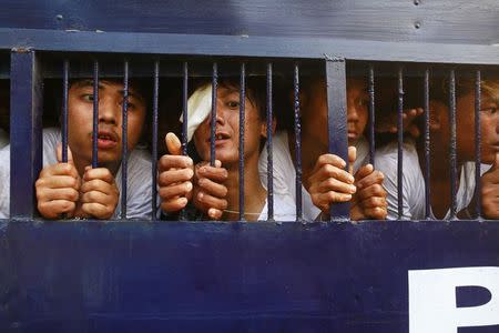 Student protesters try to speak to their family members from a prison vehicle as they are transported to a court in Letpadan March 11, 2015. REUTERS/Soe Zeya Tun