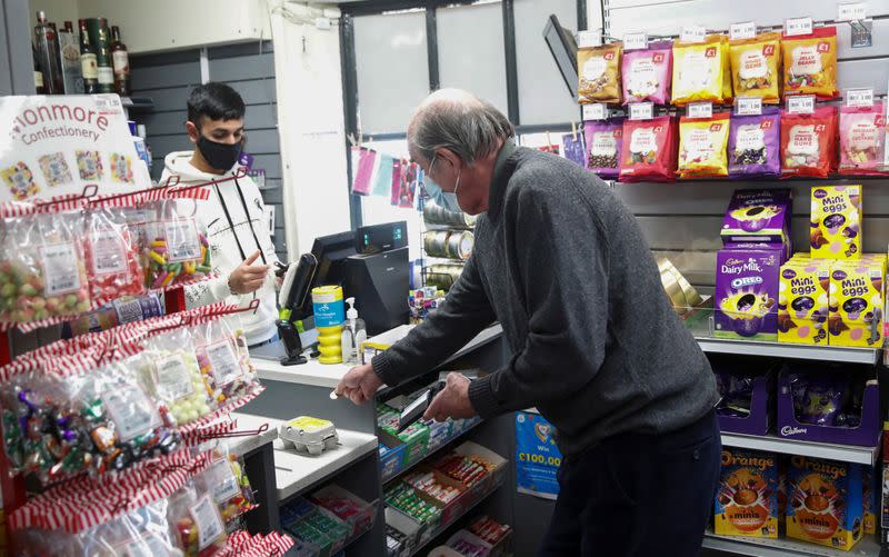 A man buys eggs from the Woburn Village Stores, a convenience store in Woburn, Britain