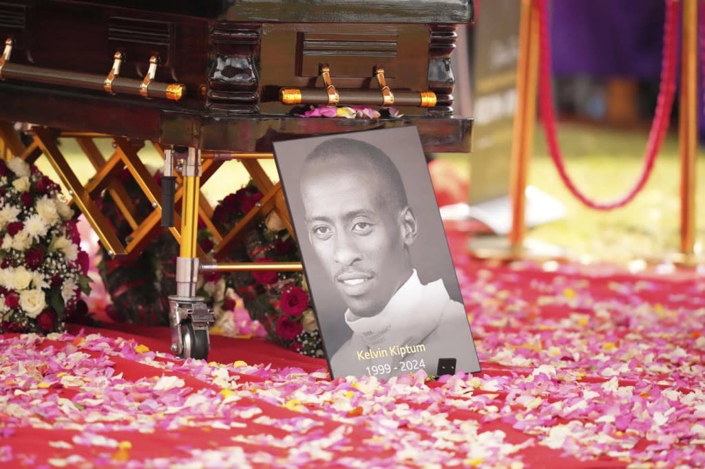 A portrait of Kelvin Kiptum next to his casket is seen ahead of his burial, in Elgeyo Marakwet, Kenya, Friday Feb. 23, 2024. (AP Photo/Brian Inganga)