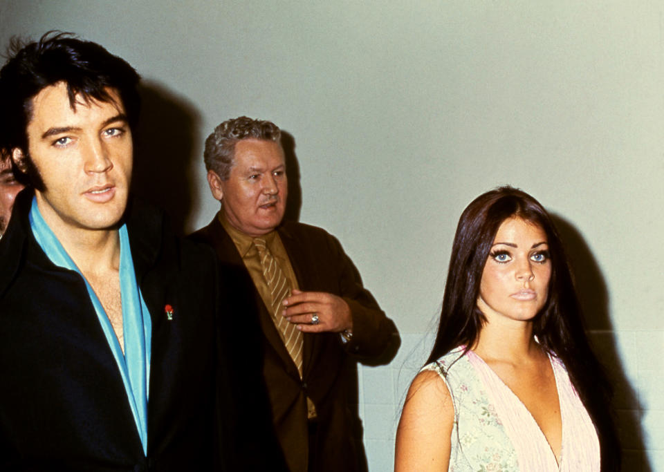 Priscilla and Elvis walking together with Vernon Presley, Elvis's father