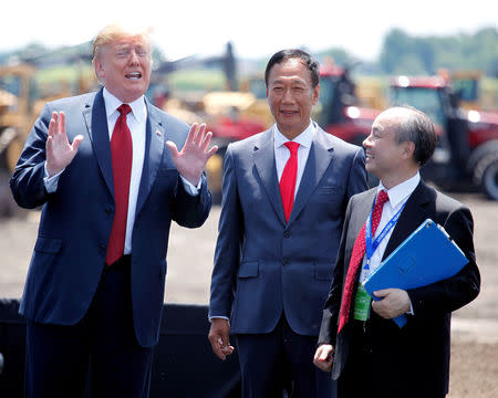 FILE PHOTO: President Donald Trump, along with Terry Gou, founder and chairman of Foxconn, and Masayoshi Son, CEO of Softbank, talk after the Foxconn Technology Group groundbreaking ceremony for its LCD manufacturing campus, in Mount Pleasant, Wisconsin, U.S., June 28, 2018. REUTERS/Darren Hauck/File Photo