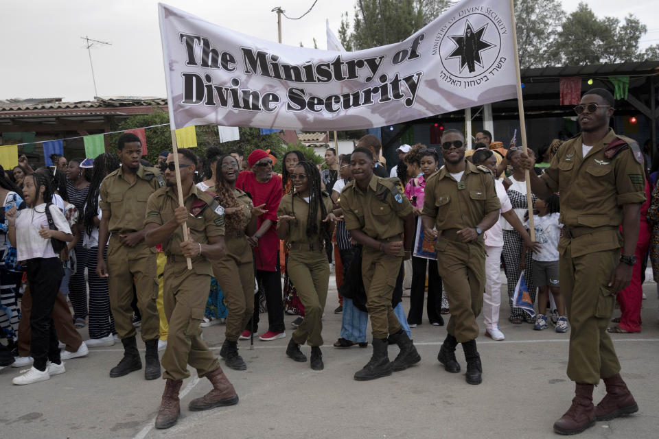 Members of the African Hebrew Israelites of Jerusalem community serving in the Israel Defence Forces dance during a procession honoring their service past their elders and community leaders during New World Passover celebrations marking the group's exodus from the United States, in Dimona, Israel, Thursday, June 1, 2023. Community leaders say they send 100 percent of their eligible sons and daughters to Israeli national military service. (AP Photo/Maya Alleruzzo)