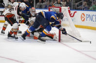 St. Louis Blues' Jake Neighbours, right, reaches for a loose puck as Anaheim Ducks goaltender Lukas Dostal and Ryan Strome (16) defend during the second period of an NHL hockey game Sunday, March 17, 2024, in St. Louis. (AP Photo/Jeff Roberson)
