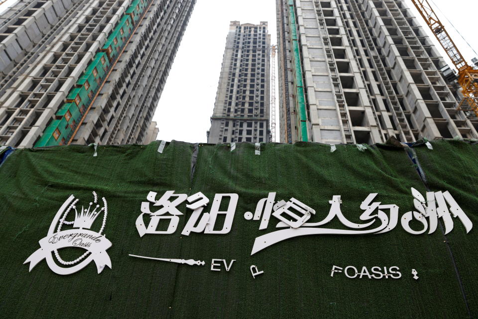 A peeling logo of the Evergrande Oasis, a housing complex developed by Evergrande Group, is pictured outside the construction site where the residential buildings stand unfinished, in Luoyang, China September 16, 2021. Picture taken September 16, 2021. REUTERS/Carlos Garcia Rawlins