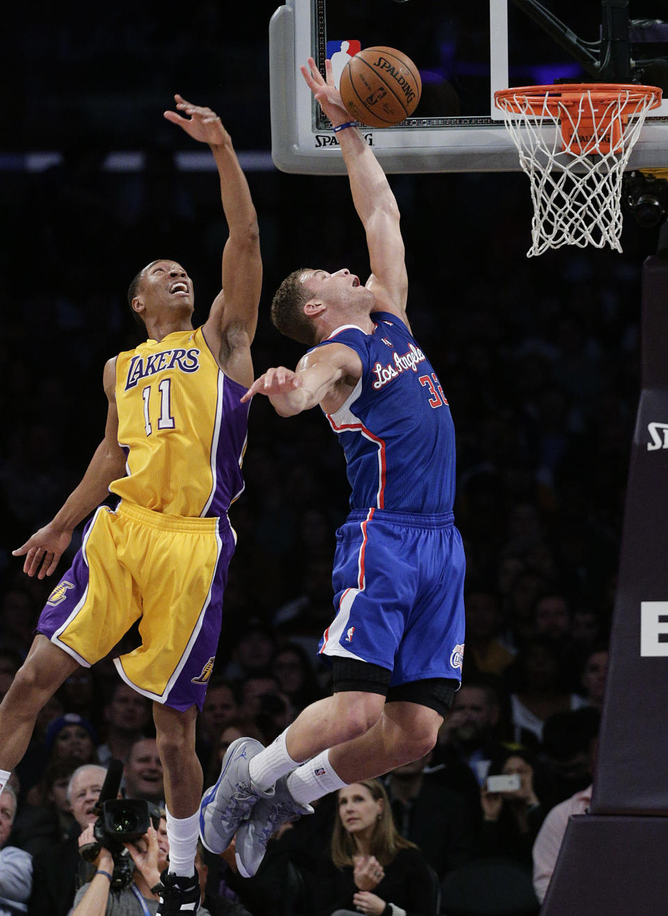 Los Angeles Clippers' Blake Griffin, center, goes up for a basket against Los Angeles Lakers' Wesley Johnson during the first half of an NBA basketball game on Thursday, March 6, 2014, in Los Angeles. (AP Photo/Jae C. Hong)