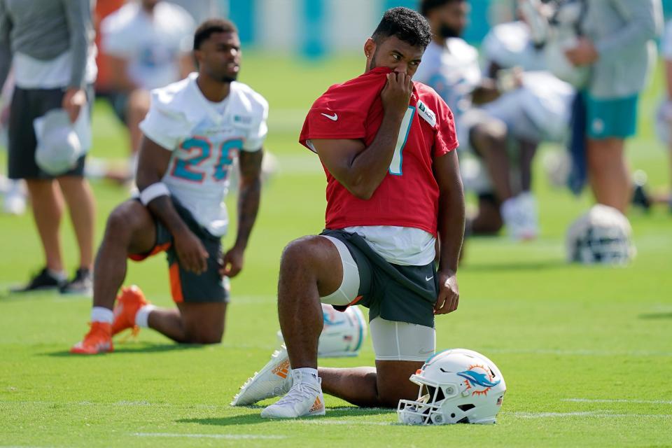 Miami Dolphins quarterback Tua Tagovailoa (1) stretches during training camp at Baptist Health Training Complex.