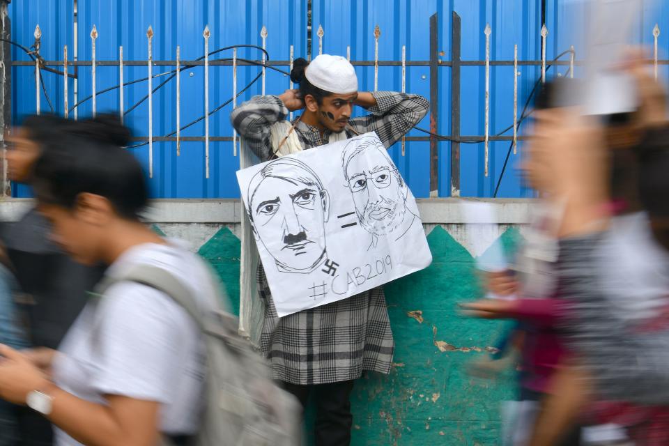 A man holds a placard comparing Indian Prime Minister Narendra Modi to German chancellor and Nazi Party leader Adolf Hitler at a protest against India's new citizenship law in Bangalore on December 17, 2019. - Fresh protests against India's new citizenship law erupted December 17 as alleged police brutality fuelled fury against the legislation which critics say is anti-Muslim. (Photo by Manjunath Kiran / AFP) (Photo by MANJUNATH KIRAN/AFP via Getty Images)