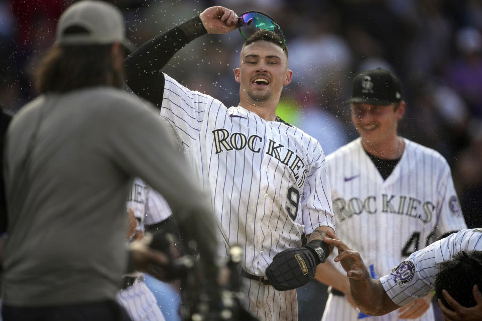 Colorado Rockies' Brenton Doyle (9) is congratulated after scoring the winning run on a wild pitch thrown by Minnesota Twins relief pitcher Jordan Luplow in the 11th inning of a baseball game Sunday, Oct. 1, 2023, in Denver. (AP Photo/David Zalubowski)