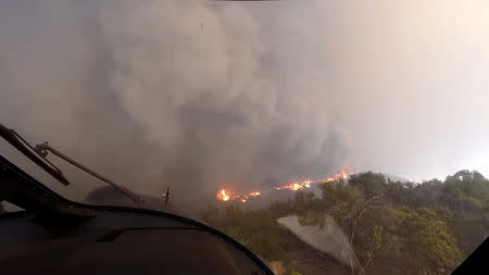 A helicopter takes off after a rescue made on the fly during the Woolsey Fire in Malibu, California, in this November 9, 2018 still image taken from helmet camera footage by LAFD David Nordquist. LAFD/David Nordquist/Social Media/via REUTERS