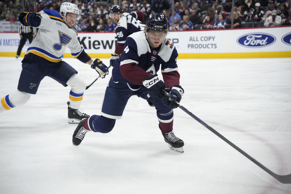 Colorado Avalanche defenseman Bowen Byram, right, reaches for the puck as St. Louis Blues left wing Jake Neighbours defends during the second period of an NHL hockey game Saturday, Nov. 11, 2023, in Denver. (AP Photo/David Zalubowski)