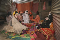 A woman talks to a Hindu holy man before the start of a procession for Shahi snan or a Royal bath during Kumbh mela, in Haridwar in the Indian state of Uttarakhand, Monday, April 12, 2021. As states across India are declaring some version of a lockdown to battle rising Covid cases as part of a nationwide second-wave, thousands of pilgrims are gathering on the banks of the river Ganga for the Hindu festival Kumbh Mela. The faithful believe that a dip in the waters of the Ganga will absolve them of their sins and deliver them from the cycle of birth and death. (AP Photo/Karma Sonam)