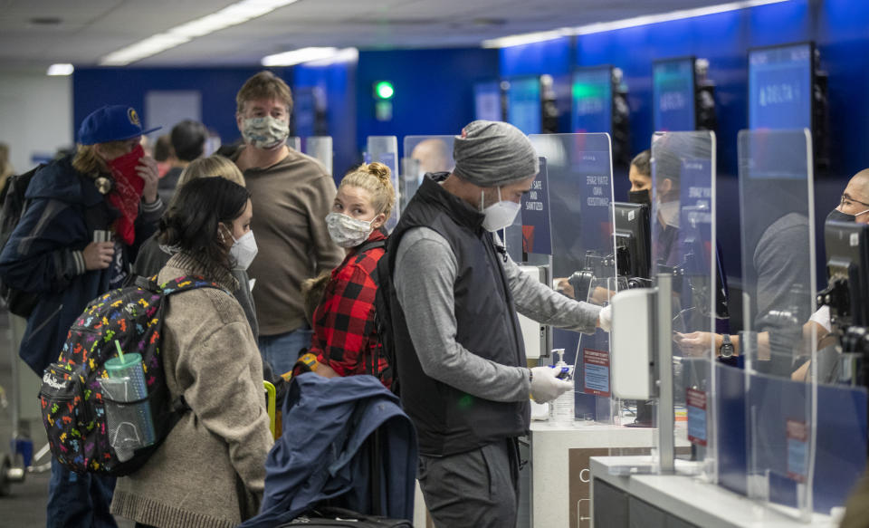 LOS ANGELES, CA - NOVEMBER 23: Travelers wearing masks get their tickets and check luggage at LAX as the Thanksgiving holiday getaway period gets underway on Monday, Nov. 23, 2020 in Los Angeles, CA. Millions of Americans are carrying on with their travel plans ahead of Thanksgiving weekend despite the CDC's urgent warnings to stay home as the number of daily cases and hospitalizations in the country continue to hit record highs. Confirmed cases in the U.S. for the disease topped 12 million on Saturday as more than 193,000 new infections were recorded in the US on Friday. This broke the previous record for the largest single-day spike on Thursday - and over 82,000 patients are now hospitalized across the country. (Allen J. Schaben / Los Angeles Times via Getty Images)