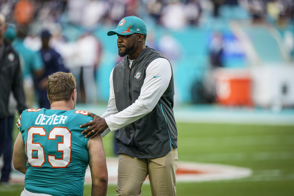 FILE - Miami Dolphins head coach Brian Flores talks with Miami Dolphins center Michael Deiter (63) ahead of the start of an NFL football game against the New England Patriots, Sunday, Jan. 9, 2022, in Miami Gardens, Fla. Fired Miami Dolphins Coach Brian Flores sued the NFL and three of its teams Tuesday, Feb. 1, 2022 saying racist hiring practices by the league have left it racially segregated and managed like a plantation. (AP Photo/Willfredo Lee, File)