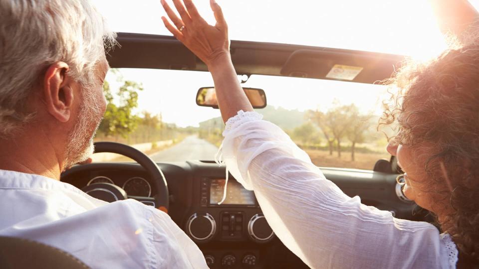 older couple on a roadtrip in a convertible