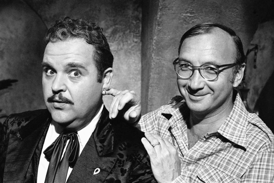 FILE- In this July 2, 1977, file photo, playwright Neil Simon, right, poses for a photo on the set of "The Cheap Detective" with Dom DeLuise. Simon, a master of comedy whose laugh-filled hits such as "The Odd Couple," "Barefoot in the Park" and his "Brighton Beach" trilogy dominated Broadway for decades, died on Sunday, Aug. 26, 2018. He was 91. (AP Photo, File)