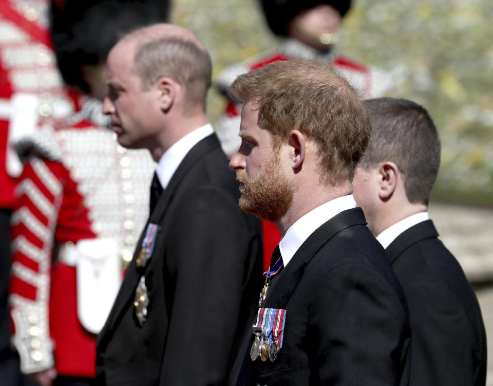 Britain's Prince William, left, and Prince Harry follow the coffin as it slowly makes its way in a ceremonial procession during the funeral of Britain's Prince Philip inside Windsor Castle in Windsor, England, Saturday, April 17, 2021. (Gareth Fuller/Pool via AP)