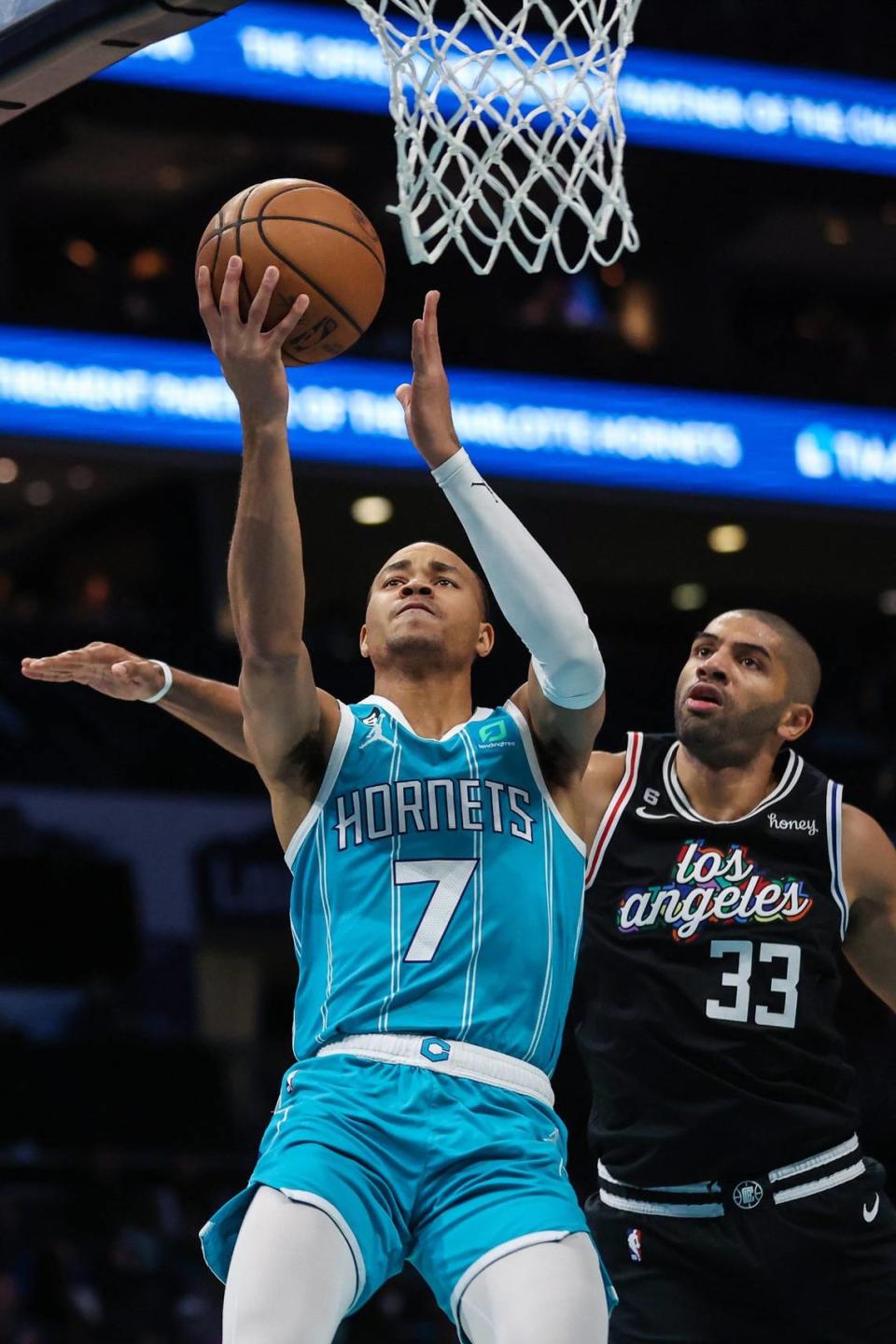 Hornets guard Bryce McGowens takes the ball to the hoop as Clippers forward Nicolas Batum defends during the game at Spectrum Center on Monday, December 5, 2022 in Charlotte, N.C.