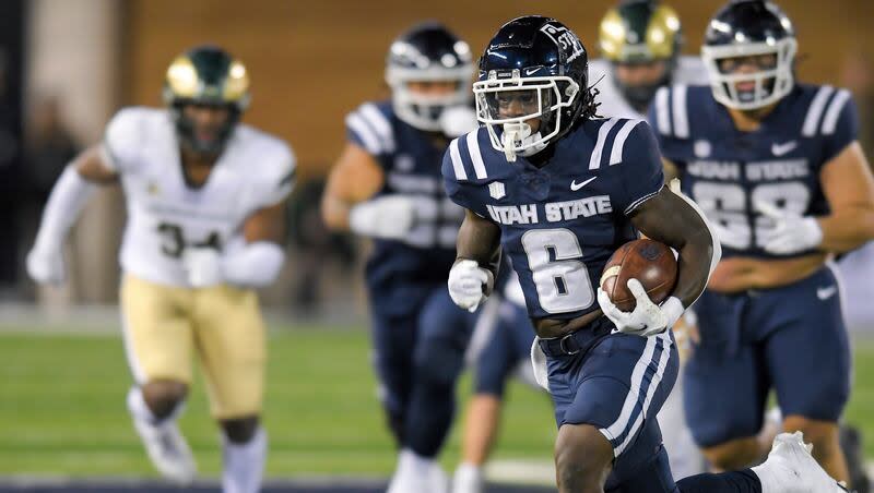 Utah State running back Davon Booth (6) carries the ball for a touchdown against Colorado State during the second half of an NCAA college football game Saturday, Oct. 7, 2023, in Logan, Utah.