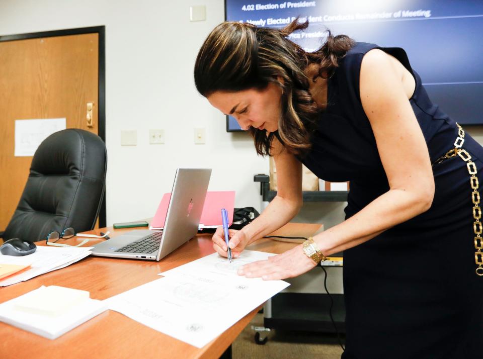 Springfield Public Schools Board member Maryam Mohammadkhani signs paperwork after being sworn in for another term on the board on Tuesday, April 9, 2024.