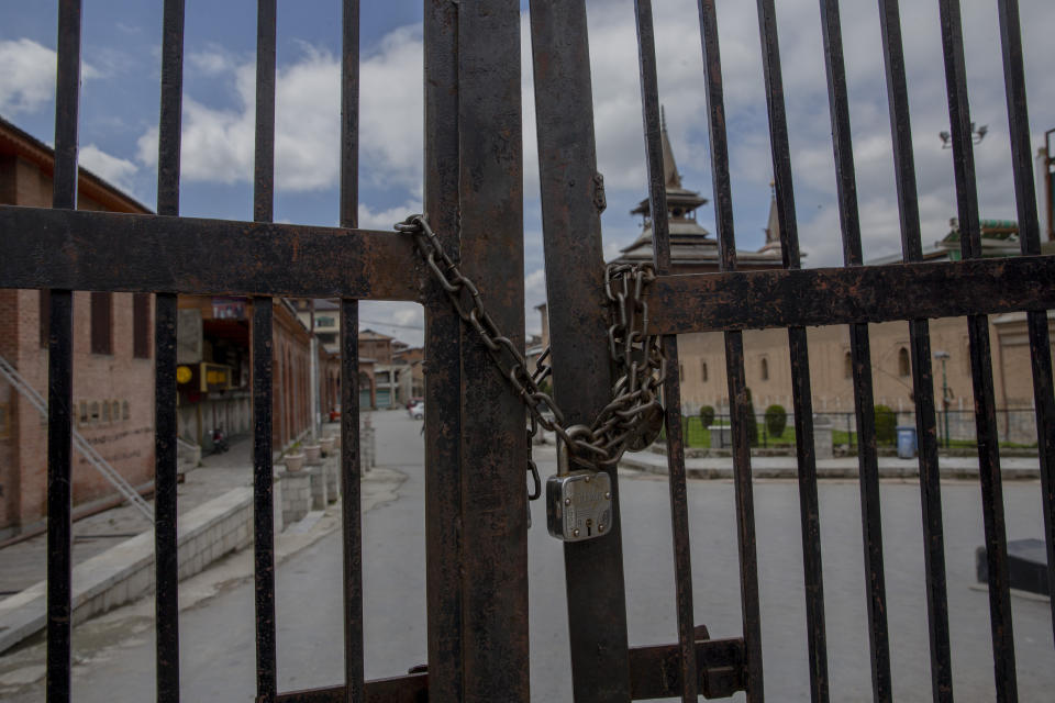 FILE- In this April 10, 2020 file photo, a lock is seen at the entrance gate of Jamia Masjid, the main mosque in Srinagar, during lockdown to check the spread of the new coronavirus in Indian controlled Kashmir. India, a bustling country of 1.3 billion people, has slowed to an uncharacteristic crawl, transforming ordinary scenes of daily life into a surreal landscape. The country is now under what has been described as the world’s biggest lockdown, aimed at keeping the coronavirus from spreading and overwhelming the country’s enfeebled health care system. (AP Photo/ Dar Yasin, File)