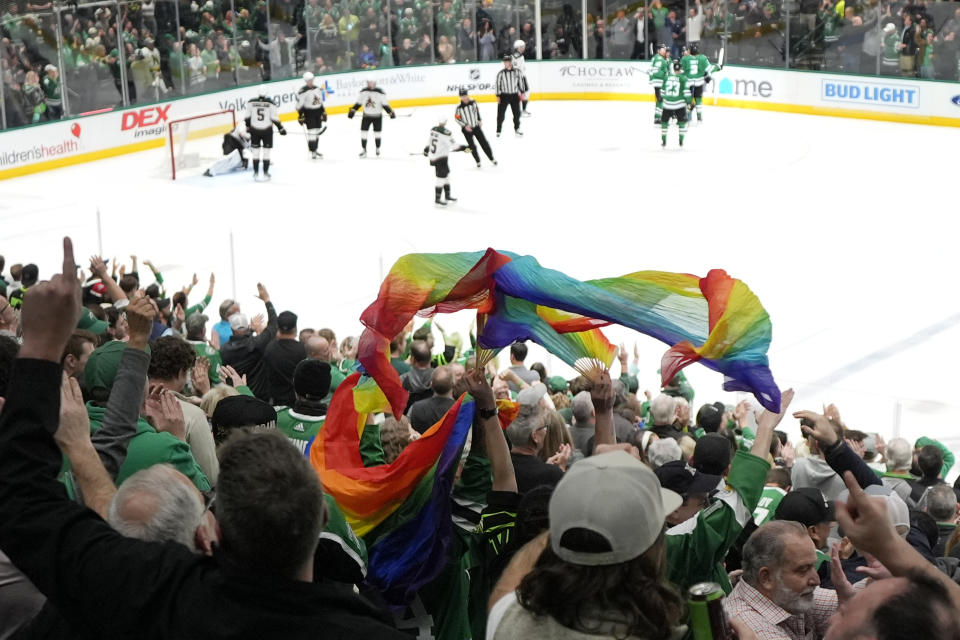 FILE - Fans wave a rainbow banner after the Dallas Stars scored against the Arizona Coyotes during the third period of an NHL hockey game in Dallas, Wednesday, March 20, 2024. The Texas Rangers have frustrated LGBTQ+ advocates for years as the only Major League Baseball team without a Pride Night. The June celebration of LGBTQ+ culture and rights known as Pride Month will come and go again without the Rangers participating. (AP Photo/Tony Gutierrez, File)