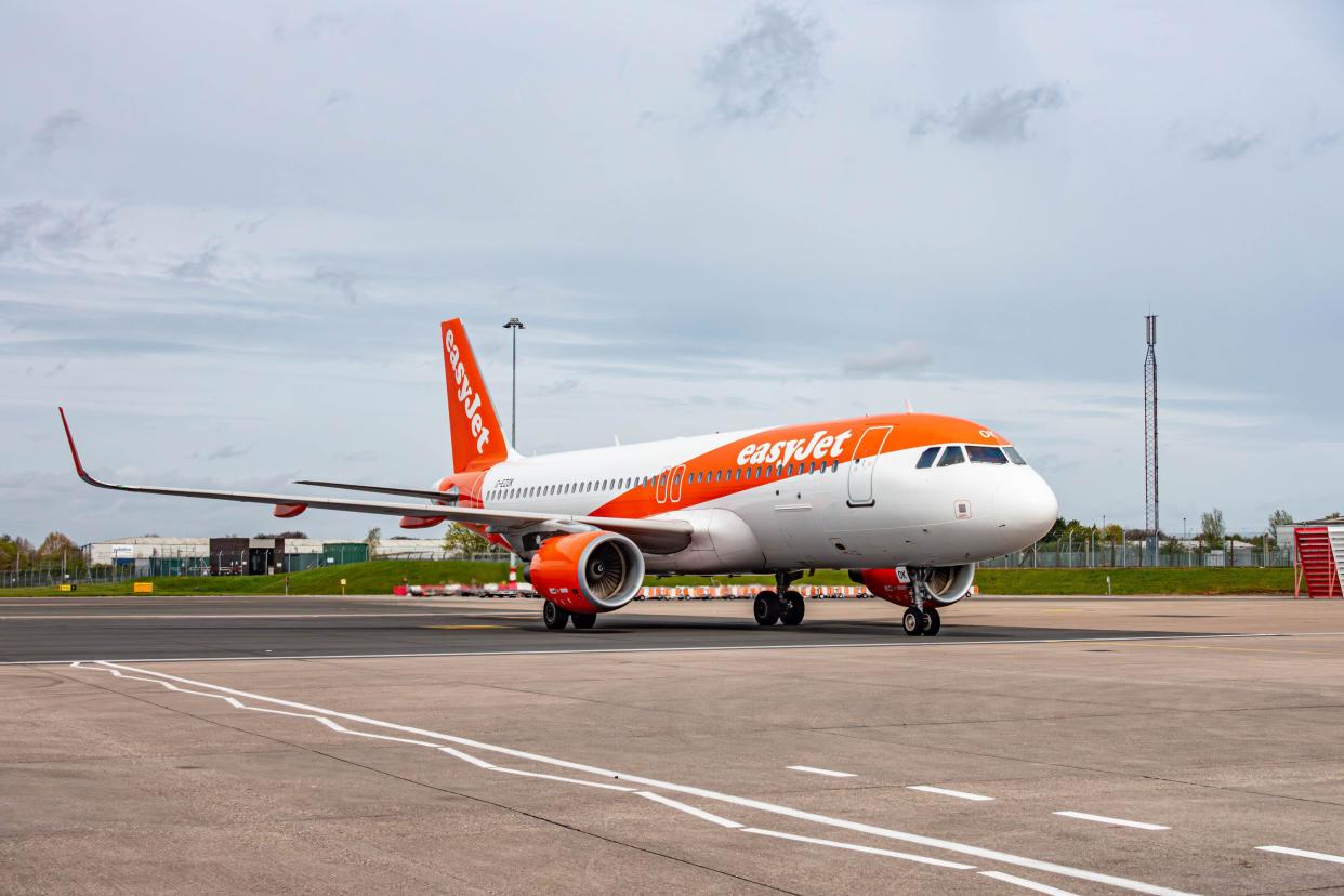 An EasyJet aeroplane in its distinctive white and orange livery taxiing at Birmingham International Airport