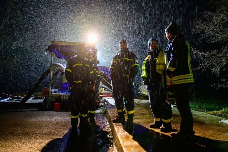 Emergency services from the THW and fire department stand at a pump. The flood situation remains tense in many regions of Lower Saxony. Philipp Schulze/dpa