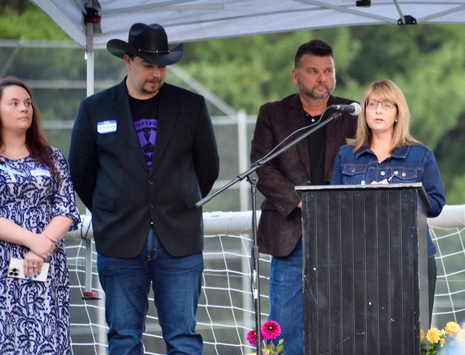 Smithsburg Town Council Vice President Tracey Knight Simane addresses the crowd Saturday night during a vigil for the victims of the Columbia Machine shooting on June 9. With her, from left, are vigil organizers Alyssa Sickle and Chandler Fishack and Washington County Commissioner Charlie Burkett.