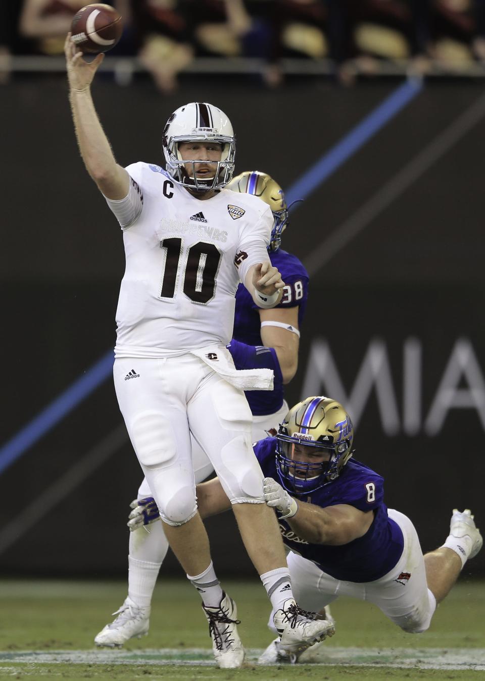 Central Michigan QB Cooper Rush in action against Tulsa's Jesse Brusker during the first half of CMU's 55-10 loss in the Miami Beach Bowl Monday in Miami.