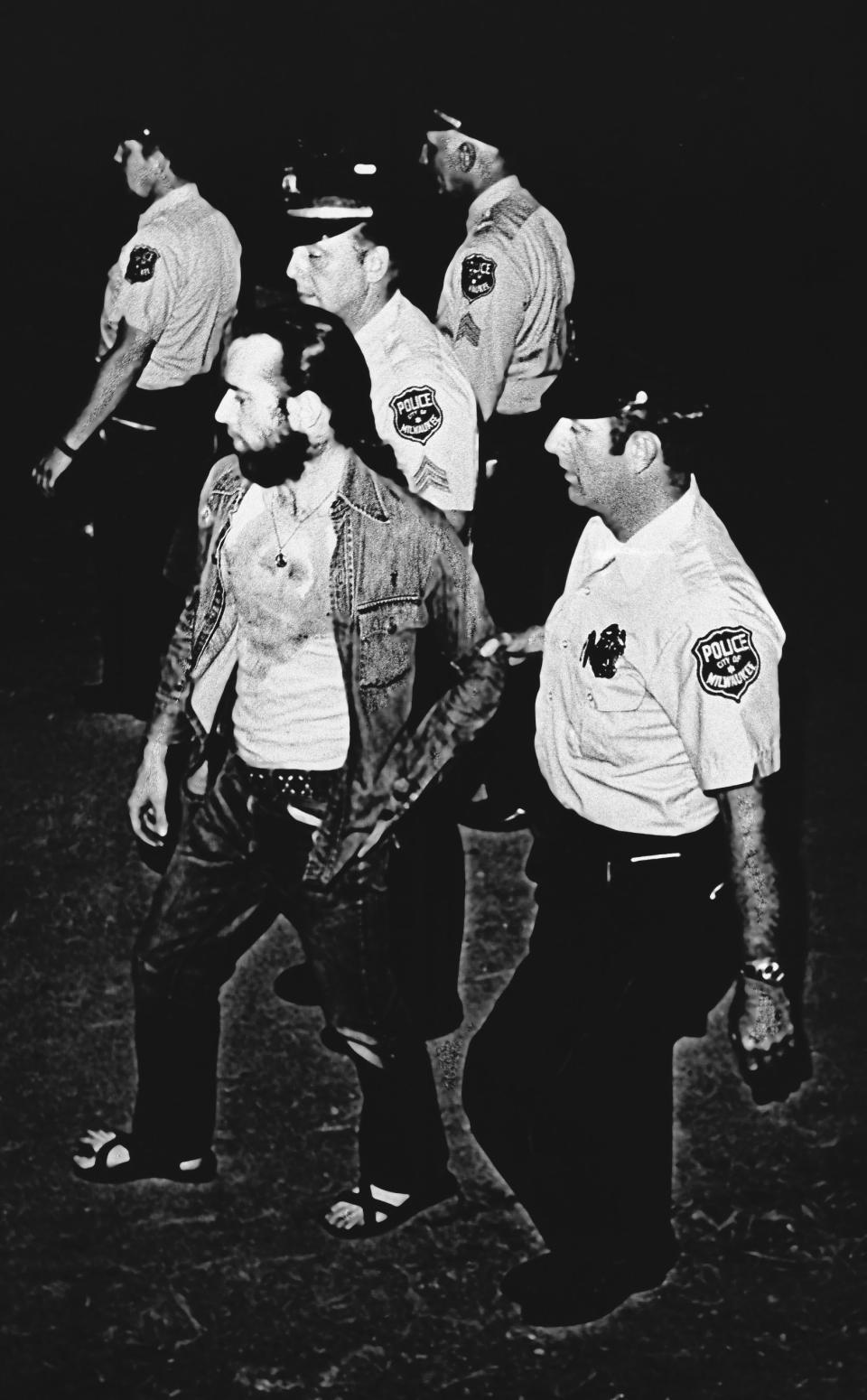 FILE - In this Friday, July 22, 1972 file photo, Milwaukee Police officers lead comedian George Carlin off the Summerfest grounds in Milwaukee, Wis. He was arrested after his act which included "The Seven Words You Can Never Say on Television," a social commentary about censorship. (AP Photo)