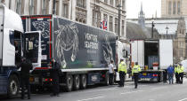 Police speak to shellfish export truck drivers as they are stopped for an unnecessary journey in London, Monday, Jan. 18, 2021, during a demonstration by British Shellfish exporters to protest Brexit-related red tape they claim is suffocating their business. The drivers were later stopped by police and issued with fines for an 'unnecessary journey' due to the national lockdown to curb the spread of the coronavirus. (AP Photo/Alastair Grant)