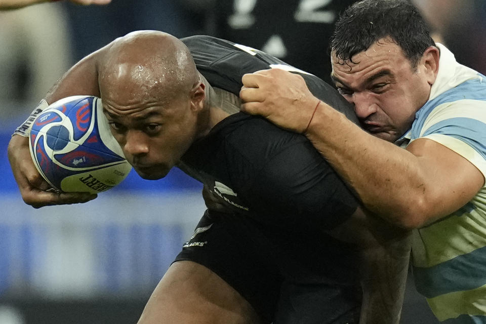 New Zealand's Mark Telea, left is grappled by Argentina's Agustin Creevy during the Rugby World Cup semifinal match between Argentina and New Zealand at the Stade de France in Saint-Denis, outside Paris, Friday, Oct 20, 2023. (AP Photo/Christophe Ena)