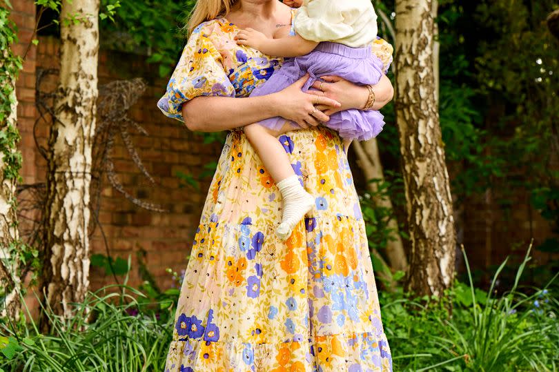 Kirsty-Leigh Porter poses in a floral dress with her second daughter Nala Rai who is now three years old