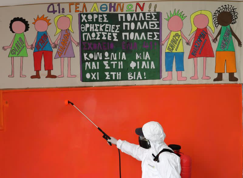 A municipal worker wearing personal protective equipment (PPE) disinfects a school, on the first day of the easing of a nationwide lockdown against the spread of the coronavirus disease (COVID-19), in Athens