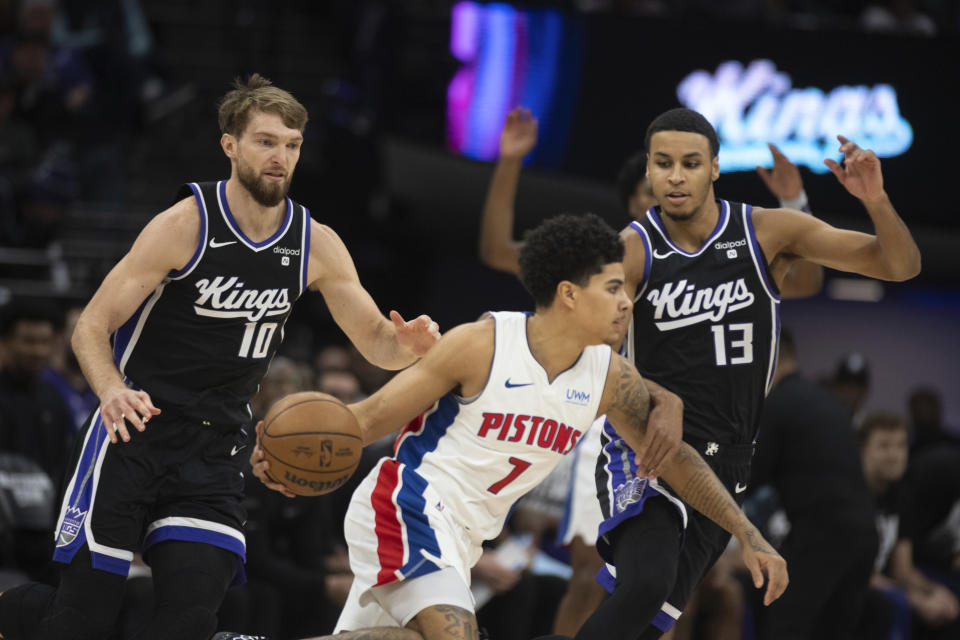 Detroit Pistons guard Killian Hayes (7) is defended by Sacramento Kings forward Domantas Sabonis (10) and forward Keegan Murray (13) during the first half of an NBA basketball game in Sacramento, Calif., Wednesday, Feb. 7, 2024. (AP Photo/José Luis Villegas)