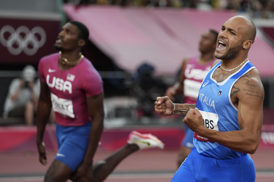 Lamont Jacobs of Italy, right, crosses the finish line to win the men's the 100-meter final besides second placed Fred Kerley of United States at the 2020 Summer Olympics, Sunday, Aug. 1, 2021, in Tokyo, Japan. (AP Photo/Matthias Schrader)