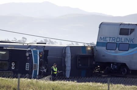 A police officer stands at the scene of a double-decker Metrolink train derailment in Oxnard, California February 24, 2015. REUTERS/Lucy Nicholson