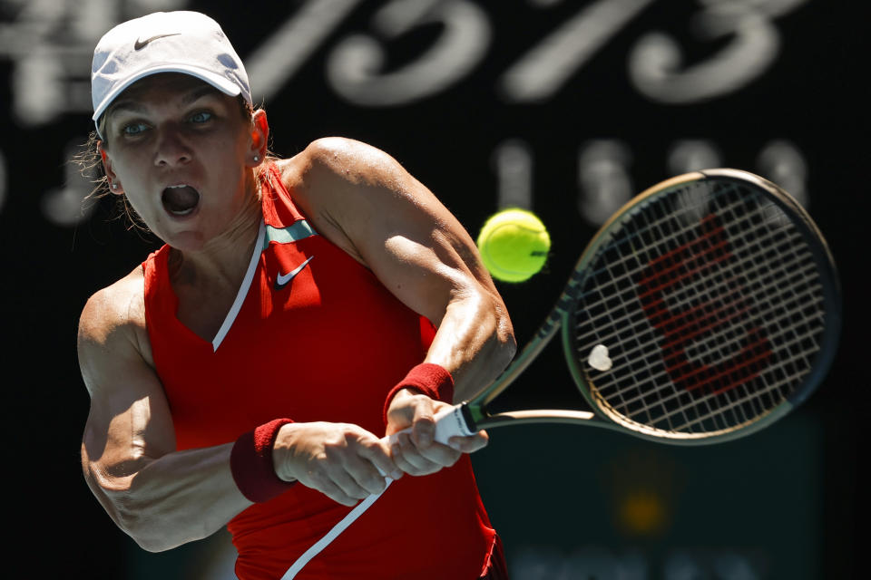 Simona Halep of Romania makes a backhand return to Alize Cornet of France during their fourth round match at the Australian Open tennis championships in Melbourne, Australia, Monday, Jan. 24, 2022. (AP Photo/Tertius Pickard)