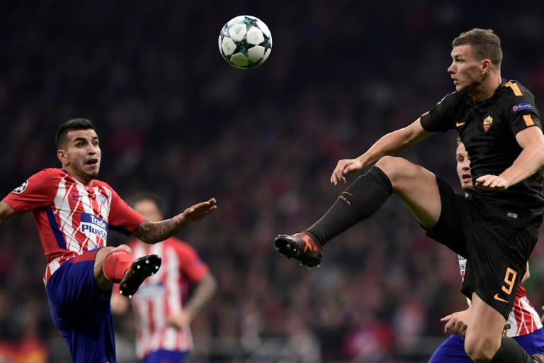 Roma's striker Edin Dzeko (R) challenges Atletico Madrid's forward Angel Correa during the UEFA Champions League group C football match November 22, 2017