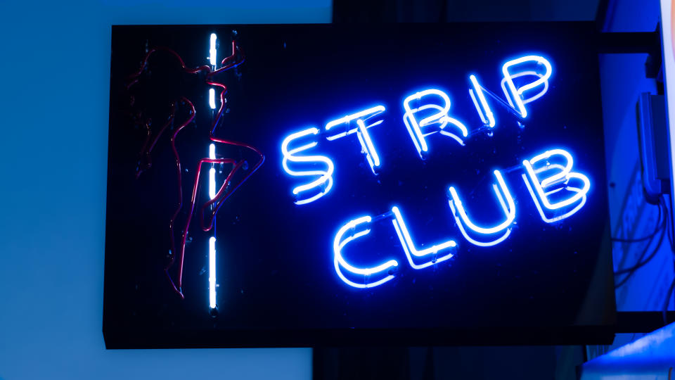 Girls strip club blue neon sign and woman silhouette.