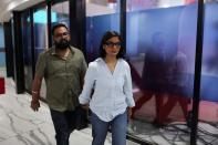 Neha Singh Rathore, 27, a folk singer and social media content creator, leaves with her husband and team member Himanshu Singh, after her debate at a national television news network in Noida