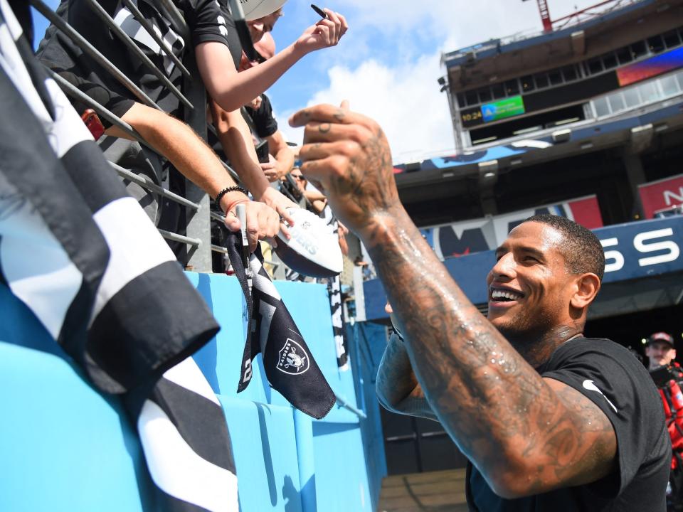 Darren Waller signs autographs for Raiders fans.