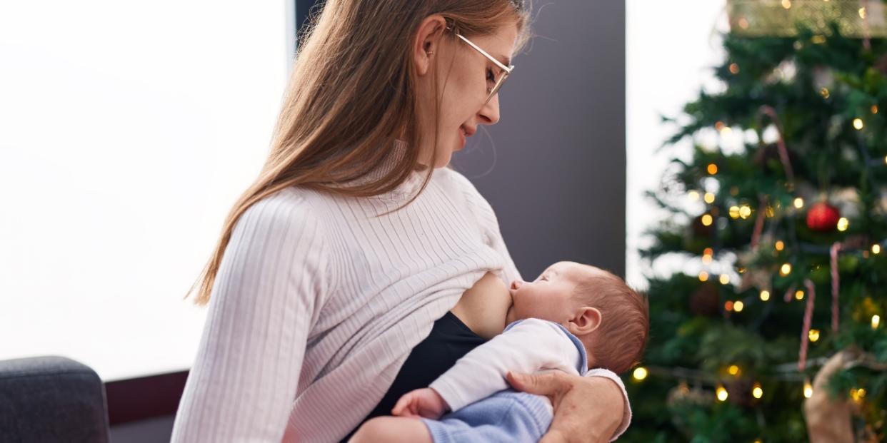 mom breastfeeding baby by Christmas tree unsolicited breastfeeding advice