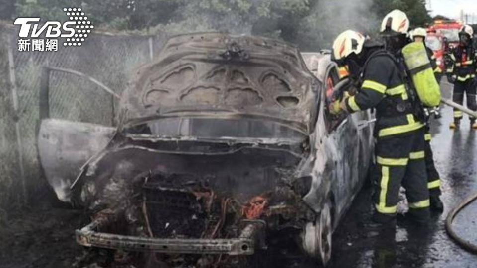 黑色轎車突然起火燃燒，消防佈水線灌救。（圖／民眾提供）