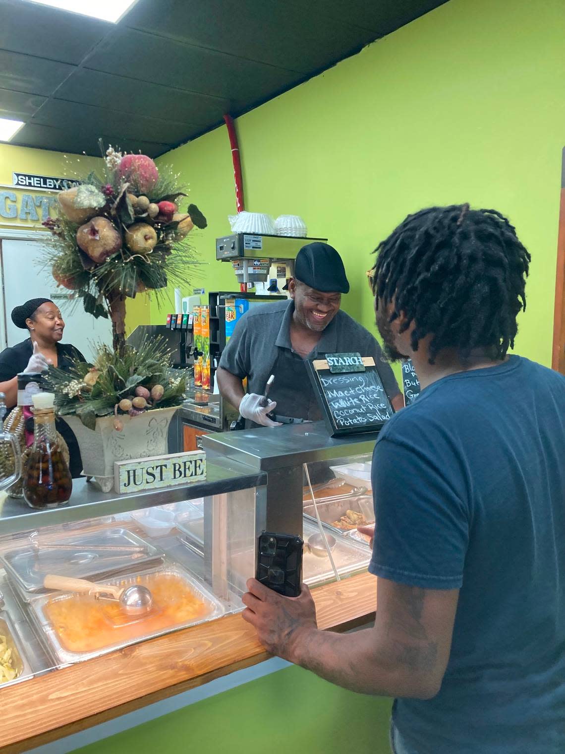 Donovan Williams selects two plates to go from a new cafeteria-style Southern and Cajun food restaurant, Hunni BJ’s Foodbar & Grill at 504 Russell Parkway in Warner Robins.